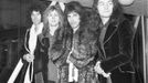 Queen na londýnském letišti Heathrow. Zleva kytarista Brian May, bubeník Roger Taylor, zpěvák Freddie Mercury a basista John Deacon, 1976.