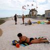 A tourist sunbathes on a former Juno Beach landing area where Canadian troops came ashore on D-Day at Bernieres Sur Mer