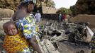 A woman stands near a vehicle, believed to belong to Islamist rebels and destroyed during French air strikes, in the recently liberated town of Diabaly January 24, 2013. REUTERS/Eric Gaillard (MALI - Tags: CIVIL UNREST CONFLICT MILITARY POLITICS) Published: Led. 24, 2013, 6:03 odp.