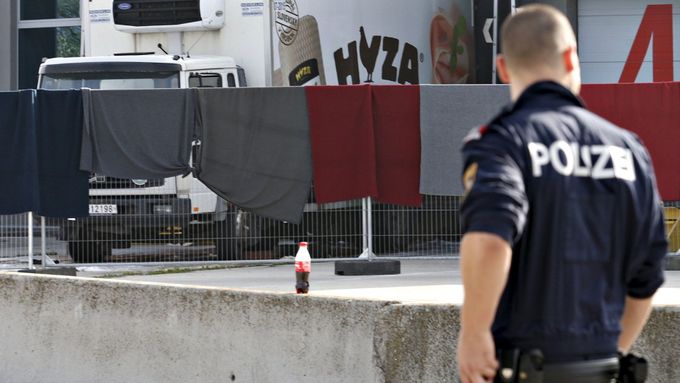 Rakouský policista u automobilu, v němž byly nalezeny ostatky sedmi desítek uprchlíků.