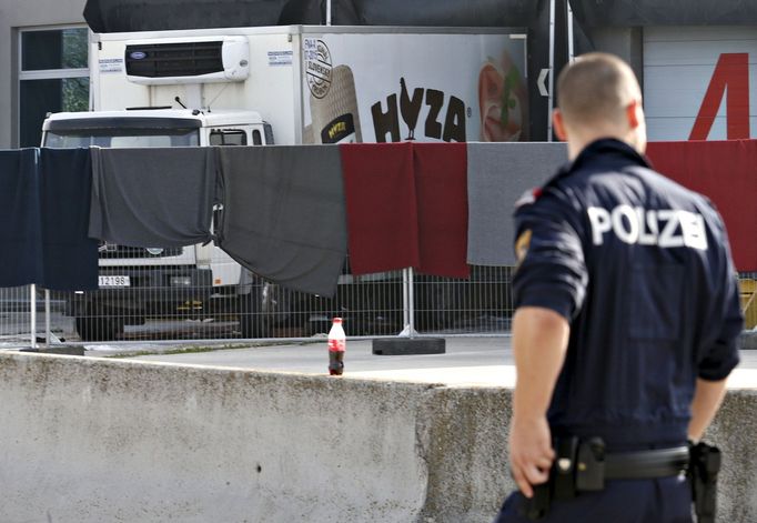 Rakouský policista u automobilu, v němž byly nalezeny ostatky sedmi desítek uprchlíků.