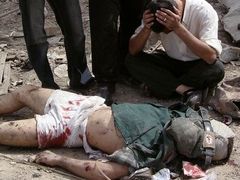Muž pláče vedle těla svého mrtvého bratra, který byl zabit po výbuchu nastražené bomby v Mahmúdiji, asi 30 kilometrů na jih od Bagdádu.