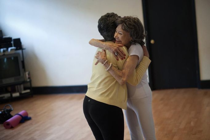 Yoga instructor Tao Porchon-Lynch hugs one of her students after leading a class in Hartsdale, New York, May 14, 2012. At 93 years old, Porchon-Lynch was named the world's oldest yoga teacher by Guinness World Records. REUTERS/Keith Bedford (UNITED STATES - Tags: SOCIETY) Published: Kvě. 14, 2012, 10:36 odp.