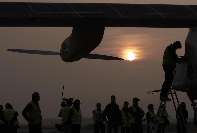 A crew member prepares the Solar Impulse aircraft before take off at Payerne airport May 24, 2012. The Solar Impulse HB-SIA prototype aircraft, which has 12,000 solar cells built into its 64.3 metres (193 feet) wings, attempted its first intercontinental flight from Payerne to Rabat in Morocco with a few days for a technical stop and a change of pilot in Madrid. This flight will act as a final rehearsal for the 2014 round-the-world flight. REUTERS/Denis Balibouse (SWITZERLAND - Tags: TRANSPORT SCIENCE TECHNOLOGY SOCIETY) Published: Kvě. 24, 2012, 7:43 dop.