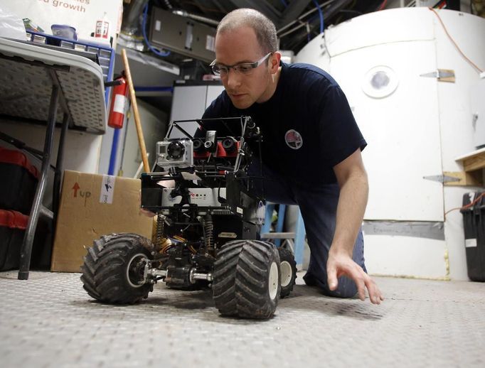 Matt Cross, an engineer with Crew 125 EuroMoonMars B mission, works on a rover at the Mars Desert Research Station (MDRS) outside Hanksville in the Utah desert March 3, 2013. The MDRS aims to investigate the possibility of a human exploration of Mars and uses the Utah desert's Mars-like terrain to simulate working conditions on the red planet. Scientists, students and enthusiasts work together developing field tactics and studying the terrain. All outdoor exploration is done wearing simulated spacesuits and carrying air supply packs and crews live together in a small communication base with limited amounts of electricity, food, oxygen and water. Everything needed to survive must be produced, fixed and replaced on site. Picture taken March 3, 2013. REUTERS/Jim Urquhart (UNITED STATES - Tags: SCIENCE TECHNOLOGY SOCIETY ENVIRONMENT) ATTENTION EDITORS: PICTURE 6 OF 31 FOR PACKAGE 'MARS IN THE DESERT' SEARCH 'JIM MARS' FOR ALL IMAGES Published: Bře. 11, 2013, 2:03 odp.