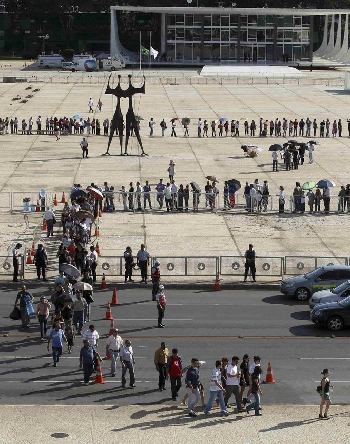 People line up in front of Planalto Palace to attend the funeral of Oscar Niemeyer in Brasilia December 6, 2012. Niemeyer, a towering patriarch of modern architecture who shaped the look of modern Brazil and whose inventive, curved designs left their mark on cities worldwide, died late on Wednesday. He was 104. Niemeyer had been battling kidney and stomach ailments in a Rio de Janeiro hospital since early November. His death was the result of a lung infection developed this week, the hospital said, little more than a week before he would have turned . REUTERS/Paulo Whitaker (BRAZIL - Tags: SOCIETY OBITUARY) Published: Pro. 6, 2012, 8:15 odp.