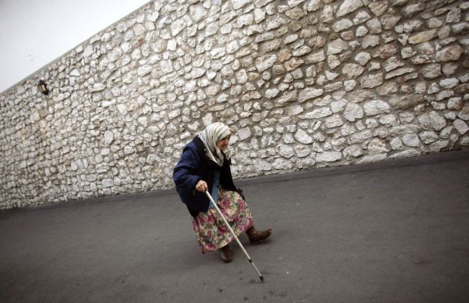 Stará žena odchází od "veřejné kuchyně". V ní rozdávají pracovníci humanitárních organizací jídlo zadarmo