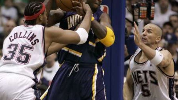 Jermaine O'Neal z Indiany (v modrém) faulovaný Jasonem Collinsem z New Jersey (vlevo). Situaci v pravo sleduje Jason Kidd.