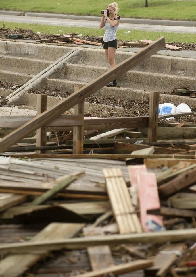 Allison Penko takes photos of the damage along Hwy. 90 left after Hurricane Isaac passed through Pass Christian, Mississippi August 30, 2012. REUTERS/Michael Spooneybarger (UNITED STATES - Tags: ENVIRONMENT DISASTER) Published: Srp. 31, 2012, 12:45 dop.