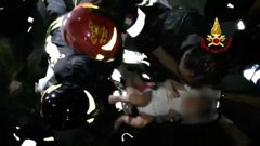 Záchranáři vytahují po zemětřesení na ostrově Ischia z trosek malého chlapce.