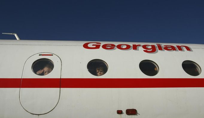 Children look out of the windows of a plane at a kindergarten in the town of Rustavi some 25 km (15 miles) south of Tbilisi, October 31, 2012. The fully functional Soviet-era Yakovlev Yak-40 plane has been installed in the kindergarten courtyard and refurbished as a children's playground. REUTERS/David Mdzinarishvili (GEORGIA - Tags: EDUCATION SOCIETY) Published: Říj. 31, 2012, 11:14 dop.