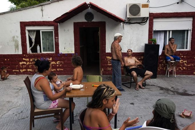 Members of the Gabarri-Echevarria family gather outside the family home at the Spanish gypsy settlement of Puerta de Hierro, in the outskirts of Madrid June 26, 2012. Fifty-four families have been living in Puerta de Hierro, on the banks of the Manzanares river for over 50 years. Since the summer of 2010, the community has been subject to evictions on the grounds that the dwellings are illegal. Families whose houses have been demolished, move in with relatives whose houses still remain while the debris keeps piling up around them as more demolitions take place. Picture taken June 26, 2012. REUTERS/Susana Vera (SPAIN - Tags: SOCIETY) ATTENTION EDITORS - PICTURE 22 OF 31 FOR PACKAGE 'GYPSY SITE DEMOLISHED' SEARCH 'GYPSY SITE' FOR ALL IMAGES Published: Lis. 5, 2012, 4:12 odp.