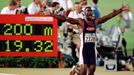 FILE PHOTO: Michael Johnson of the U.S. celebrates as he runs by the stadium clock with his new world record of 19.32 posted after he broke his old record in the men's 20