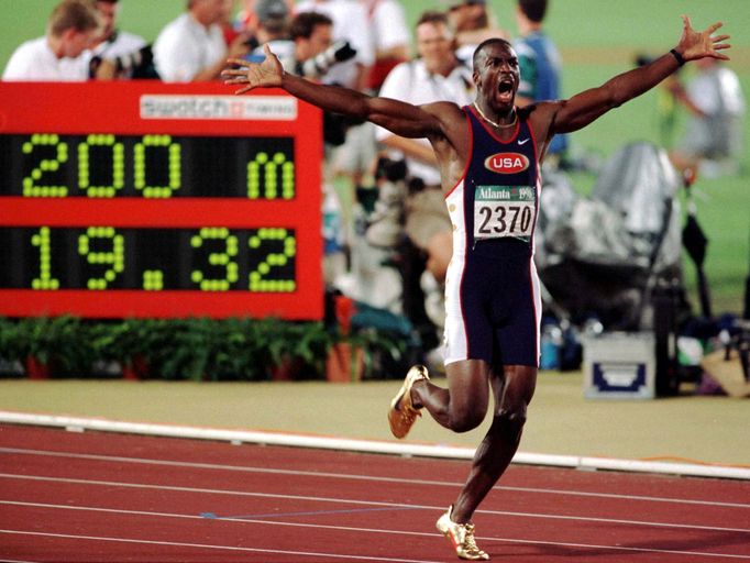 FILE PHOTO: Michael Johnson of the U.S. celebrates as he runs by the stadium clock with his new world record of 19.32 posted after he broke his old record in the men's 20