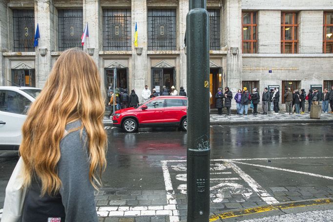 Městská knihovna v Praze a turisté čekající na fotku se sloupem z knih, tzv. Idiomem.