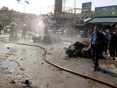 V Bagdádu dnes vybuchly tři bomby, zahynulo nemně 32 lidí. Požárníci se snaží uhasit plameny způsobené jedním z výbuchů.