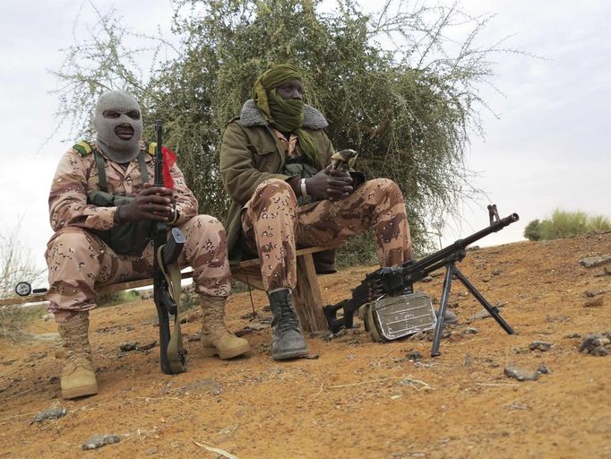 Malian soldiers with their faces covered sit on a bench in the recently recaptured town of Gao January 27, 2013. French and Malian troops retook the major Saharan trading towns of Gao and Timbuktu from Islamist rebels at the weekend. Picture taken January 27, 2013. REUTERS/Adama Diarra (MALI - Tags: POLITICS CIVIL UNREST MILITARY TPX IMAGES OF THE DAY) Published: Led. 31, 2013, 9:37 dop.