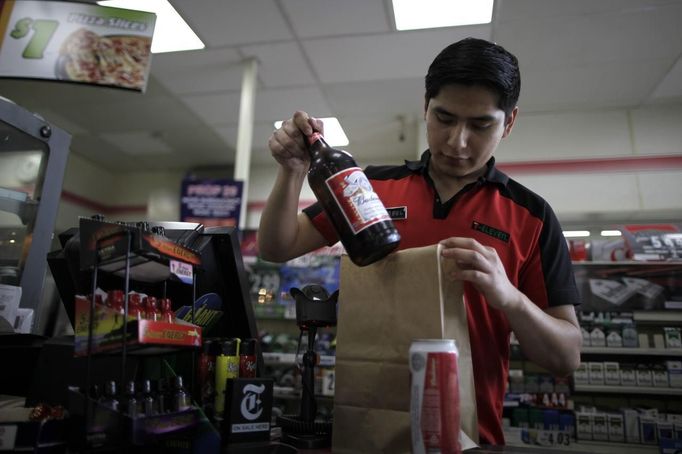 Abel Santiago, 21, serves a customer at a 7-Eleven convenience store in Santa Monica, California April 24, 2012. Santiago studied for one year at Universidad Anahuac Oaxaca for a degree in law. He has worked at the store for five months and hopes to return to Mexico to finish his degree.