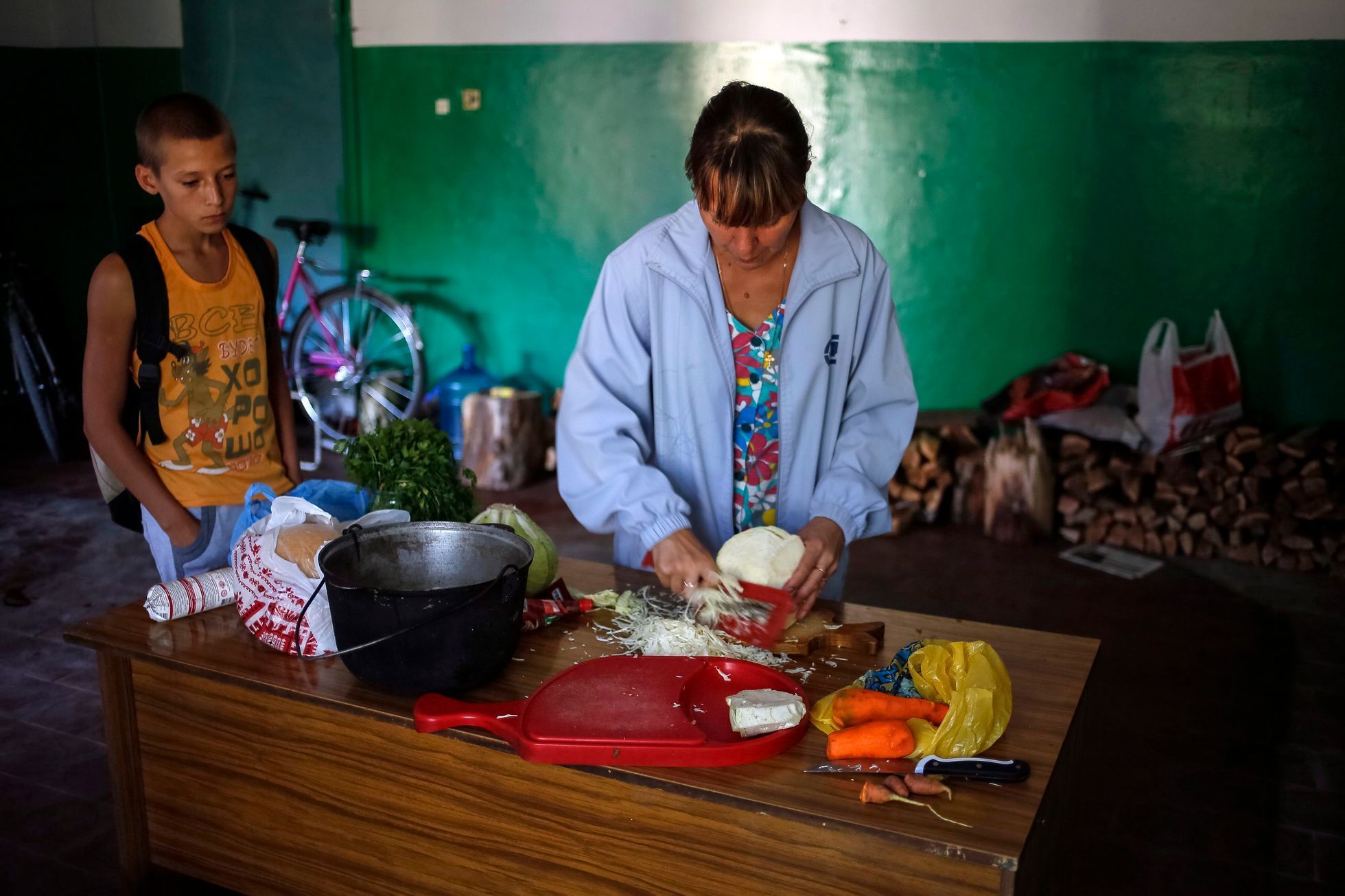 Ukrajina - žena připravuje jídlo ve městě poblíž Doněcku