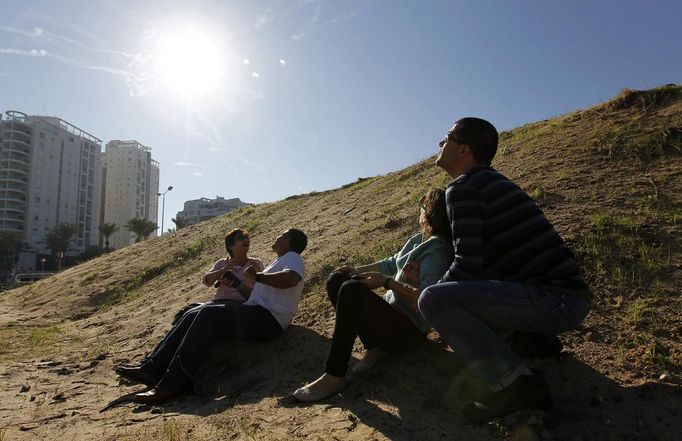 Israeli people look up at the sky with smoke trails from an Iron Dome interceptor rocket and try to take cover as a siren sounds warning of incoming rockets in Ashdod November 15, 2012. Hamas fired dozens of rockets into southern Israel on Thursday, killing three people, and Israel launched numerous air strikes across the Gaza Strip, threatening a wider offensive to halt repeated Palestinian salvoes. REUTERS/Amir Cohen (ISRAEL - Tags: CIVIL UNREST) Published: Lis. 15, 2012, 9:42 dop.