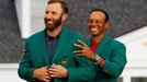 Golfista Dustin Johnson dostává od Tigera Woodse zelené sako pro vítěze Masters