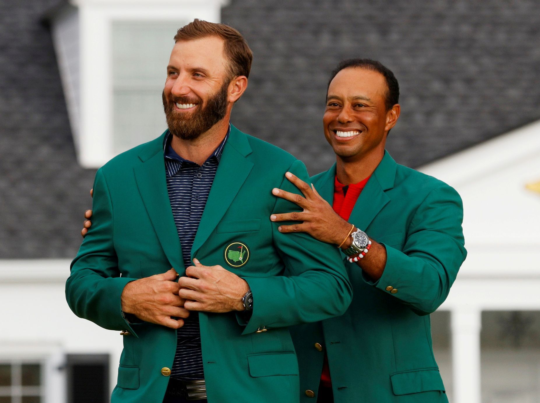 Nejhezčí fotky Reuters 2020 - Golfista Dustin Johnson dostává od Tigera Woodse zelené sako pro vítěze Masters