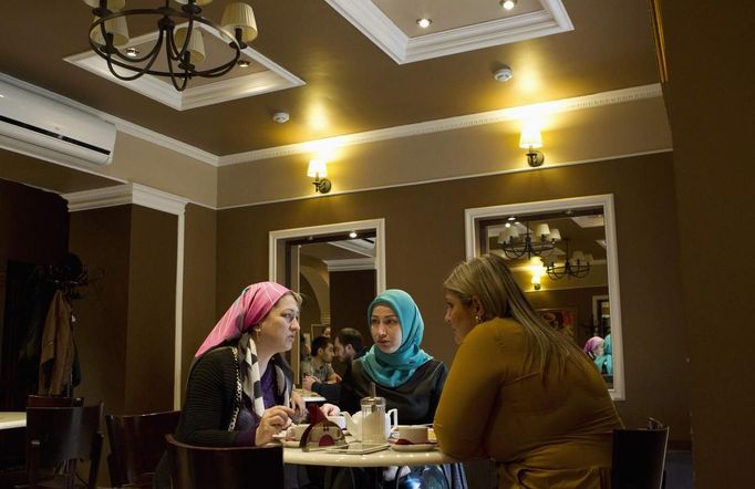 Chechen women chat in a cafe in the centre of the Chechen capital Grozny April 23, 2013. The naming of two Chechens, Dzhokhar and Tamerlan Tsarnaev, as suspects in the Boston Marathon bombings has put Chechnya - the former site of a bloody separatist insurgency - back on the world's front pages. Chechnya appears almost miraculously reborn. The streets have been rebuilt. Walls riddled with bullet holes are long gone. New high rise buildings soar into the sky. Spotless playgrounds are packed with children. A giant marble mosque glimmers in the night. Yet, scratch the surface and the miracle is less impressive than it seems. Behind closed doors, people speak of a warped and oppressive place, run by a Kremlin-imposed leader through fear. Picture taken April 23, 2013. REUTERS/Maxim Shemetov (Russia - Tags: SOCIETY POLITICS FOOD) ATTENTION EDITORS: PICTURE 26 OF 40 FOR PACKAGE 'INSIDE MODERN CHECHNYA'. SEARCH 'REBUILDING CHECHNYA' FOR ALL IMAGES Published: Kvě. 1, 2013, 8:08 dop.