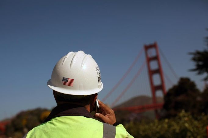 A worker talks on a cell phone near the new Bridge Pavilion on the south end of the Golden Gate Bridge as the iconic landmark is prepared for its 75th anniversary in late May, in San Francisco, California May 7, 2012. Enhancements such as a Bridge Pavilion serving as a visitor intrepretation center, art deco Round House for a virtual photo experience, and additional bicycle and walking trails have been added ahead of the May 27 anniversary. REUTERS/Robert Galbraith (UNITED STATES - Tags: ANNIVERSARY SOCIETY) Published: Kvě. 7, 2012, 6:50 odp.