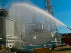 Aby ochladili poničený reaktor 3 jaderné elektrárny ve Fukušimě, stříkají na něj hasiči vodu.