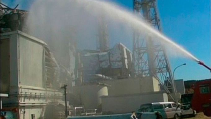 Aby ochladili poničený reaktor 3 jaderné elektrárny ve Fukušimě, stříkají na něj hasiči vodu.