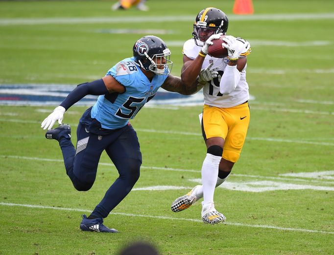 Oct 25, 2020; Nashville, Tennessee, USA; Pittsburgh Steelers wide receiver JuJu Smith-Schuster (19) catches a pass as he is defended by Tennessee Titans outside linebacke