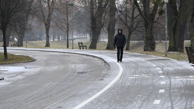 Muž jde po namrzlém chodníku na sídlišti Podvesná ve Zlíně, 23. ledna 2024.