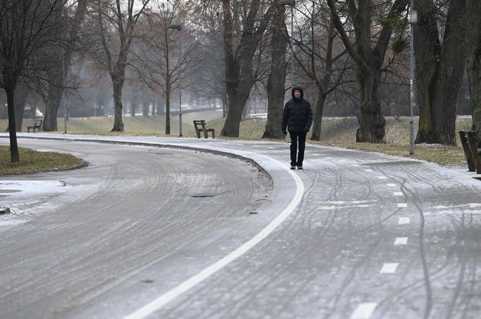 Muž jde po namrzlém chodníku na sídlišti Podvesná ve Zlíně, 23. ledna 2024.