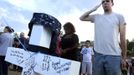 Airman 1st Class Andrew Zayatz salutes a cross with the name of Navy member John Thomas Larimer at the memorial site for the people killed by the gunman in the Century 16 theater, in Aurora, Colorado July 22, 2012. Zayatz serves currently at Peterson Air Force Base in Colorado Springs. REUTERS/Jeremy Papasso (UNITED STATES - Tags: CRIME LAW MILITARY) Published: Čec. 23, 2012, 2:56 dop.