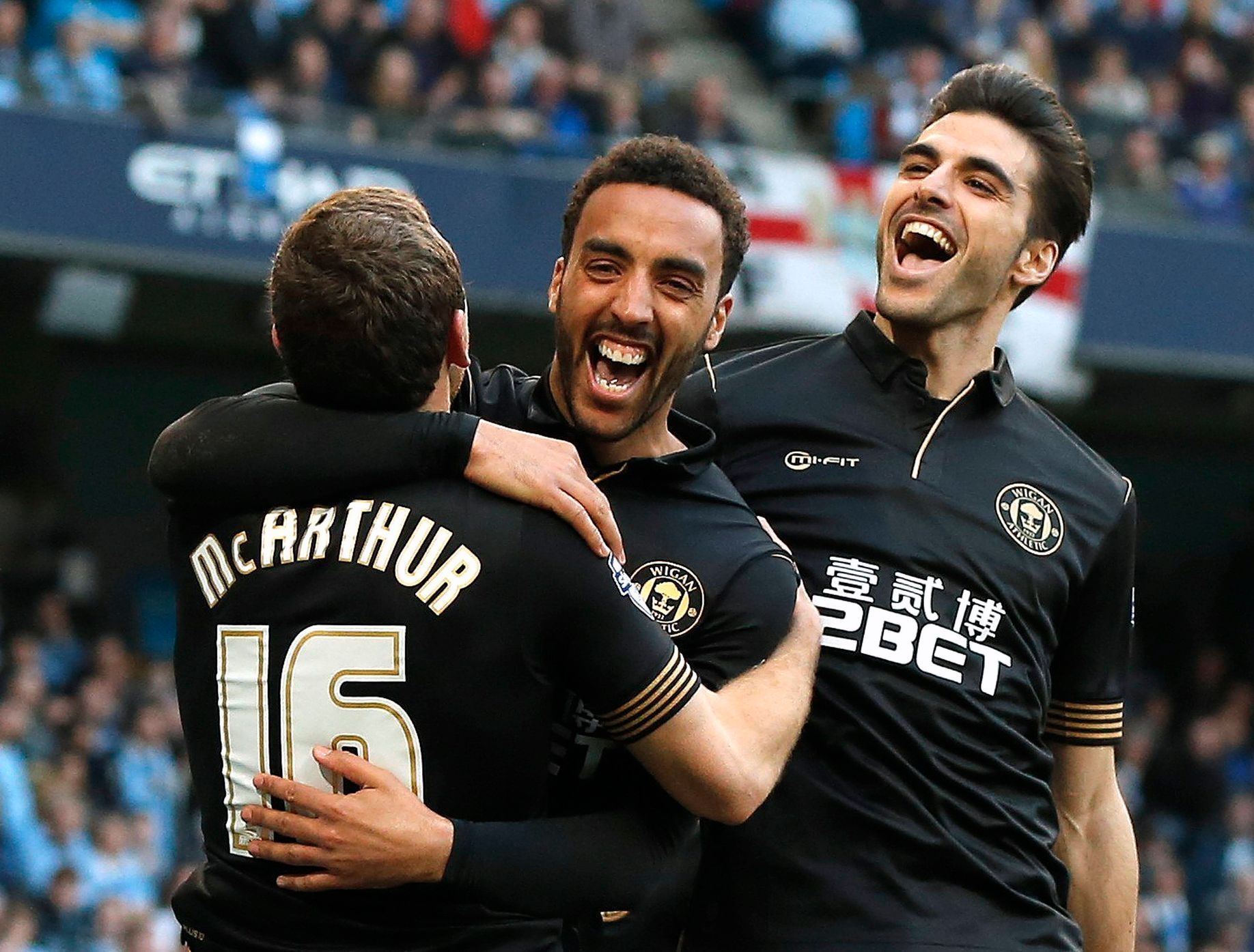 Wigan Athletic's Perch celebrates with teammates McArthur and Gomez after scoring a goal against Manchester City during their English FA Cup quarter final match in Manchester