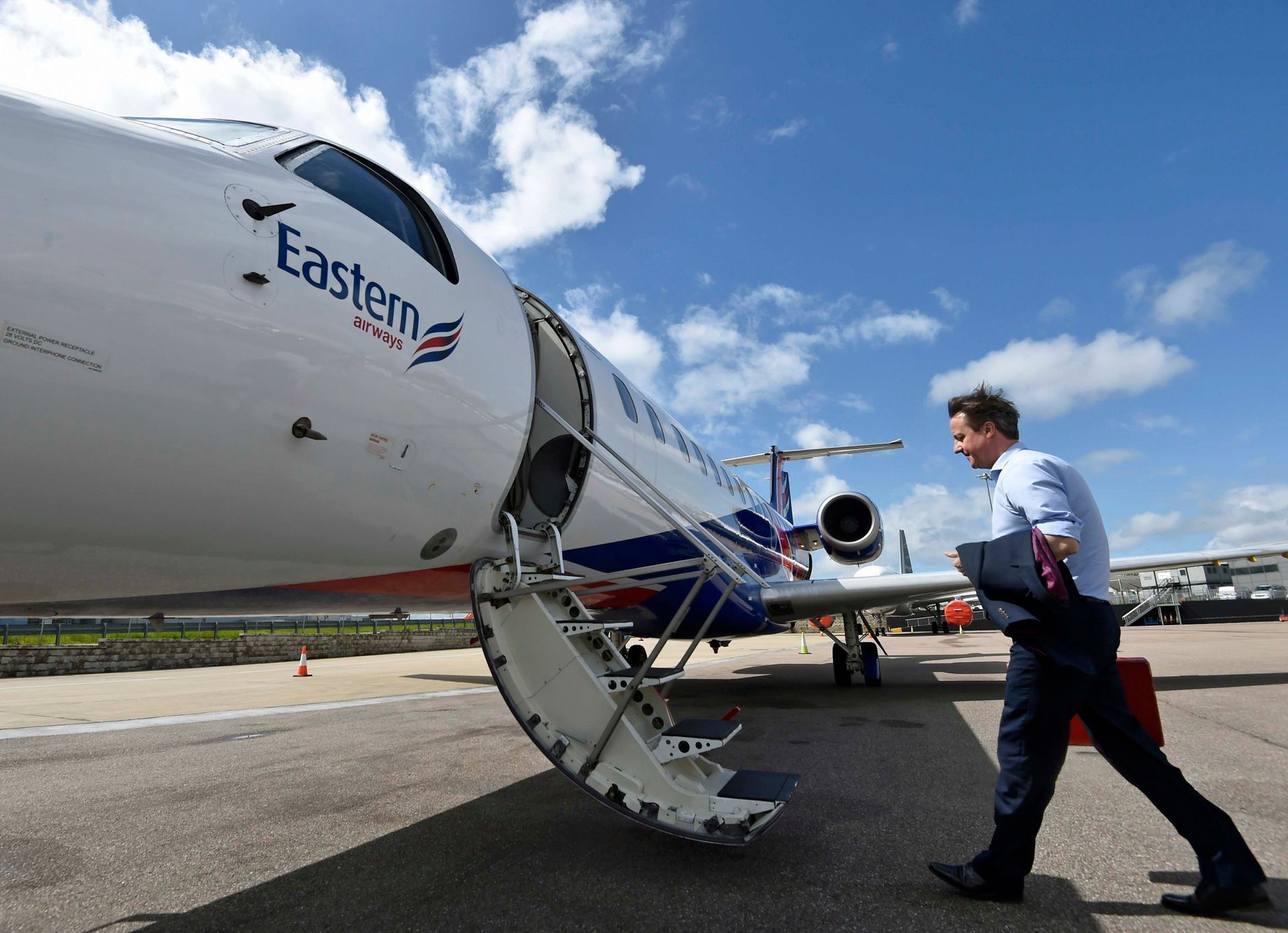 Britský premiér David Cameron nastupuje do letadla na londýnském letišti Luton.
