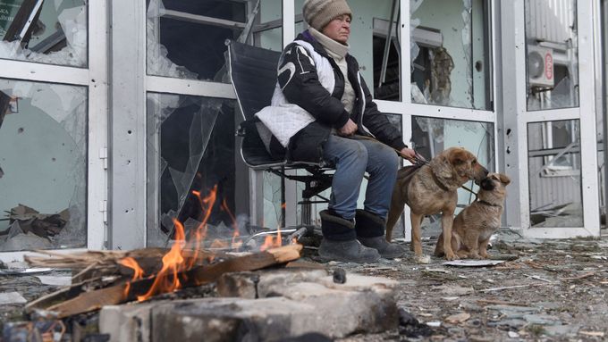Žena sedí před zničeným domem v městě Volnovacha v doněckém regionu, které ovládají separatisté,