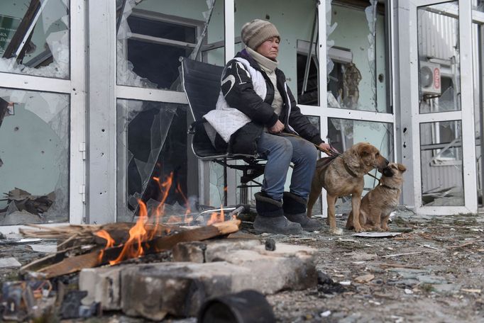 Žena sedí před zničeným domem v městě Volnovacha v doněckém regionu, které ovládají separatisté,