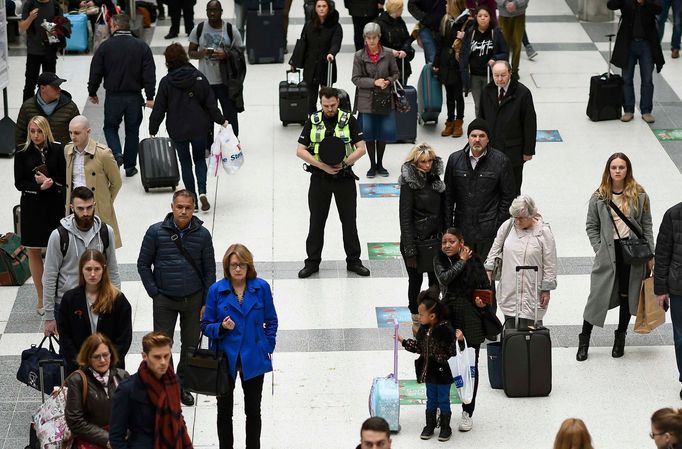 People pause to observe a minute's silence in memory of the victims of the Paris shootings, at Liverpool Street Station in London, Britain November 16, 2015.