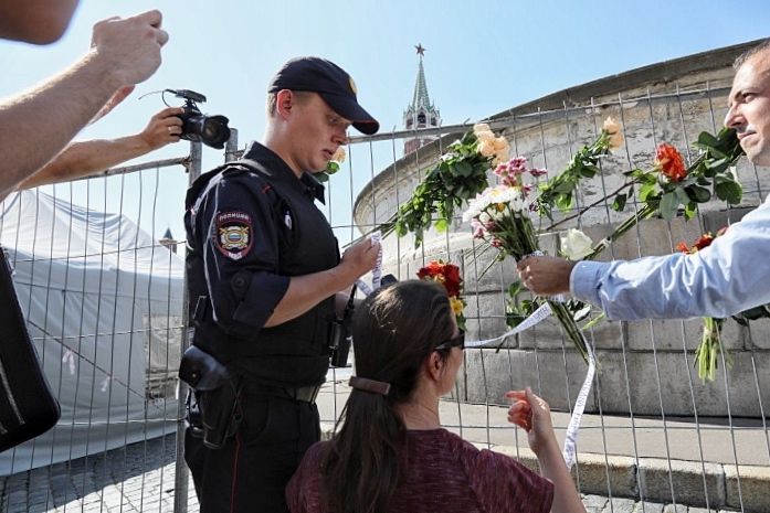 Policista shazuje květy Rudé náměstí
