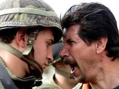 Izraelský voják a nespokojený Palestinec.