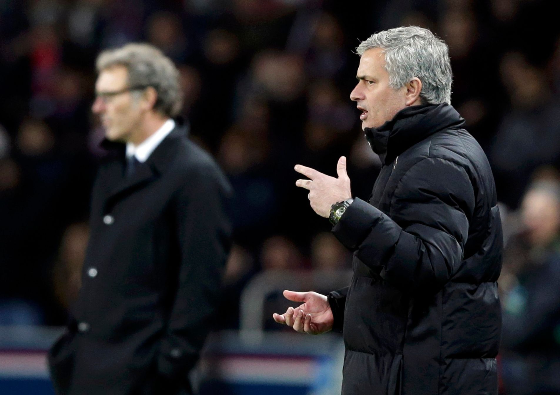 Chelsea's coach Mourinho reacts near Paris St Germain's coach Blanc during their Champions League round of 16 first leg soccer match at the Parc des Princes Stadium in Paris