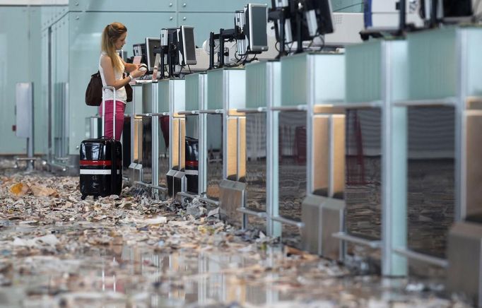 A passenger stands at the check-in desks during a protest by the cleaning staff at Barcelona's airport May 29, 2012. Cleaning staff working for a company which has a contract with the airport demonstrated against pay and benefits cuts made by their employer. REUTERS/Albert Gea (SPAIN - Tags: CIVIL UNREST BUSINESS TRANSPORT) Published: Kvě. 29, 2012, 5:24 odp.