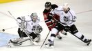 Jonathan Quick hlídá puk na hokejce Stephena Gionty, kterého brání Colin Fraser během druhého utkání finále play-off NHL mezi New Jersey Devils a Los Angeles Kings.