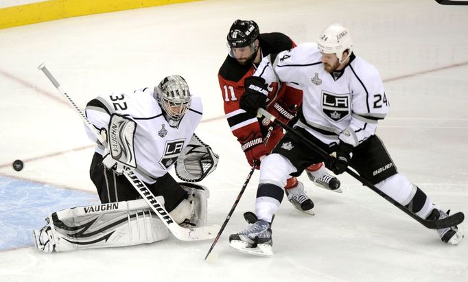 Jonathan Quick hlídá puk na hokejce Stephena Gionty, kterého brání Colin Fraser během druhého utkání finále play-off NHL mezi New Jersey Devils a Los Angeles Kings.