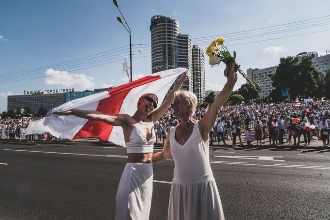 Běloruské ženy v bílém a s květinami protestovaly proti policejnímu násilí.