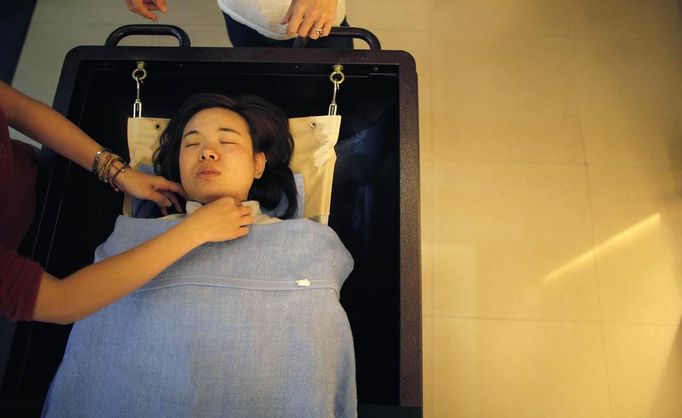 Students practice with a volunteer during their undertaker service class at the Tianquanjiajing Funeral Service school in Jiaxing, Zhejiang province May 29, 2012. A new breed of young Chinese undertakers are fighting centuries-old taboos to gain social acceptance for their profession, saying they help the deceased and their families make their final parting with respect. There are more than 1,500 students across the country studying to become undertakers each year. Courses in funeral services take three years to complete and the service includes washing of the dead body as well as providing funeral make-up and dressing. Picture taken May 29, 2012. REUTERS/Carlos Barria (CHINA - Tags: SOCIETY) ATTENTION EDITORS - PICTURE 06 OF 17 FOR PACKAGE 'FUNERAL SERVICE STUDENTS' Published: Čer. 7, 2012, 2:43 dop.