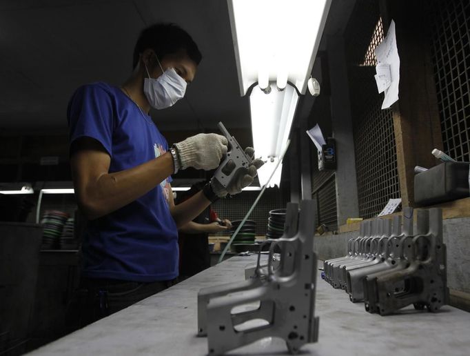 A former illegal gunsmith inspects a newly molded body of a caliber 45 pistol at Shooters Arms, a gun manufacturing company exporting different kinds of weapons to other countries, in Cebu city in central Philippines July 6, 2012. In the Philippines, they vote with their trigger fingers. Elections mean big business for illegal gunsmiths, who are looking forward to 2013 mid-term polls. With election-related violence commonplace, the Philippines imposes a ban on the carrying of guns for six months, from campaigning to the proclamation of winners. Picture taken July 6, 2012. To match Feature PHILIPPINES-GUNS/ REUTERS/Erik De Castro (PHILIPPINES - Tags: SOCIETY POLITICS BUSINESS CRIME LAW) Published: Čec. 29, 2012, 1:37 dop.