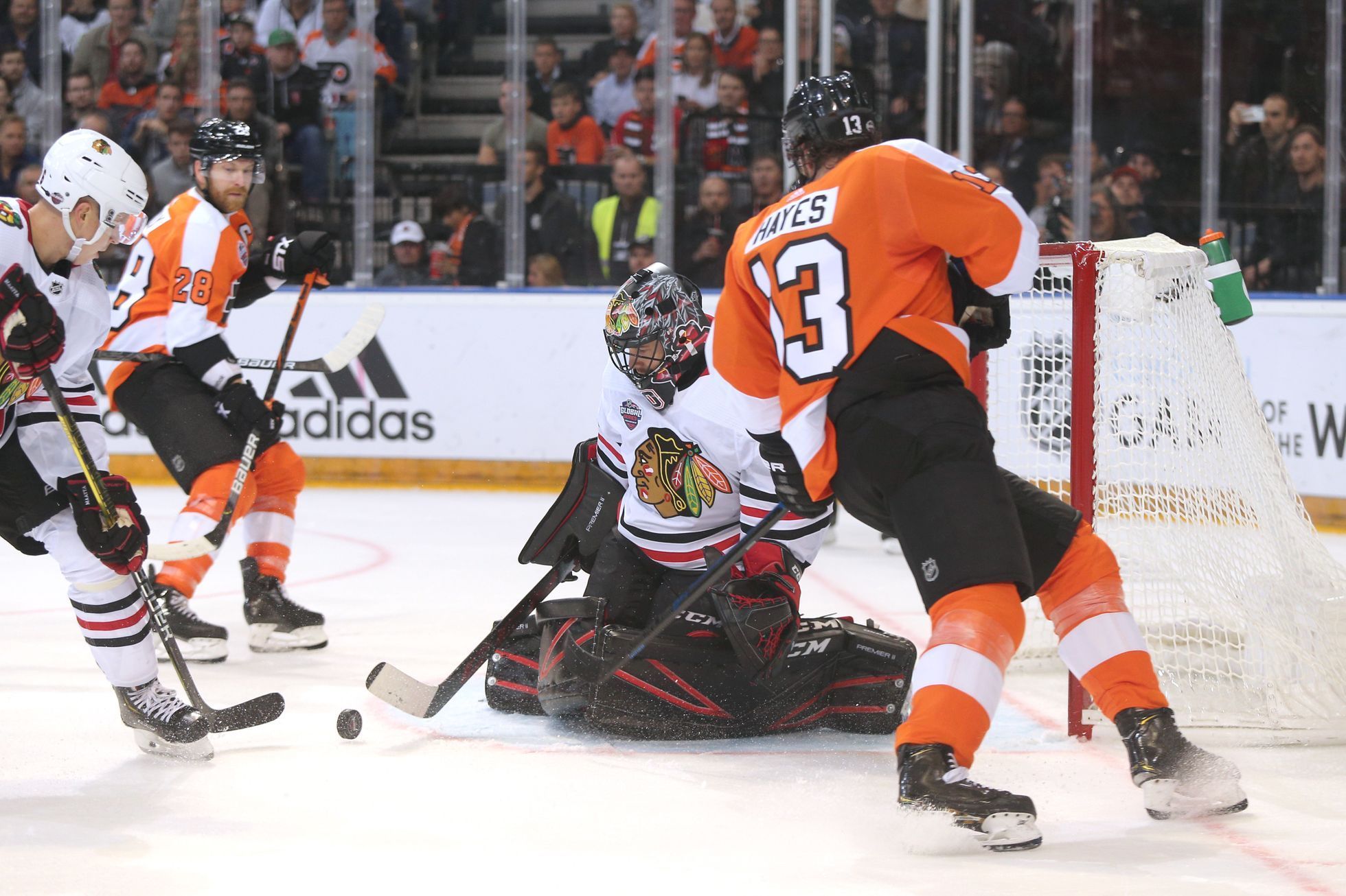 NHL v Praze: Philadelphia - Chicago: Kevin Hayes (v oranžovém) v souboji proti brankáři Coreymu Crawfordovi