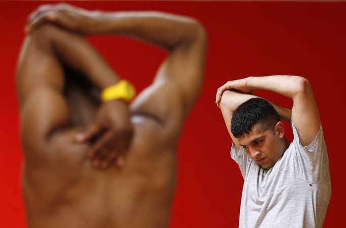 Unemployed Belgian Mohamed Sammar stretches during a "Fit for a job" boxing class in Brussels July 1, 2013. Sammar, 27, has been looking for a job in the construction sector for 2 years. "Fit for a job" is the initiative of former Belgian boxing champion Bea Diallo, whose goal was to restore the confidence of unemployed people and help them find a job through their participation in sports. Picture taken July 1, 2013. REUTERS/Francois Lenoir (BELGIUM - Tags: SPORT BOXING SOCIETY BUSINESS EMPLOYMENT) Published: Čec. 5, 2013, 4:36 odp.